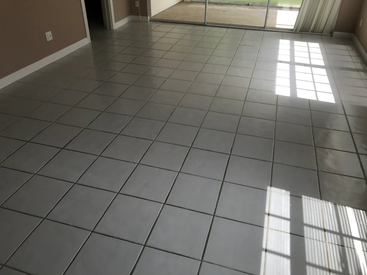 Tile floor before color grout sealing — stained, dark grout lines
